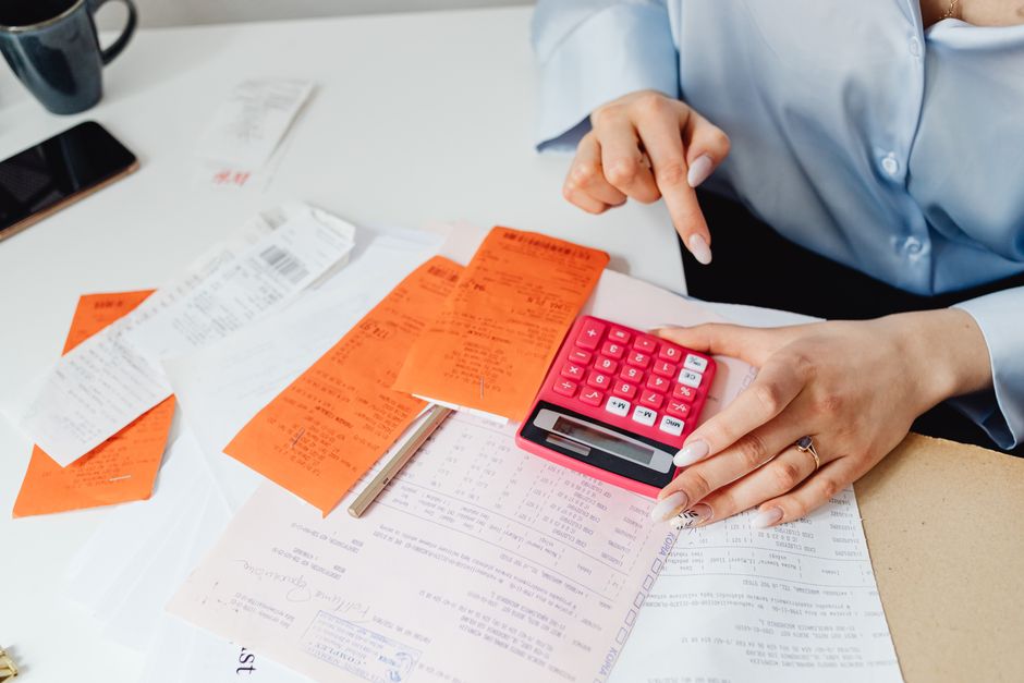 Persona con calculadora y recibos haciendo el cálculo del IVA trimestral