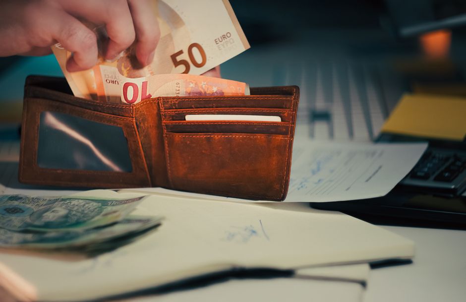 Cartera con billetes de euro sobre una mesa, la paga extra tras aplicar el IRPF