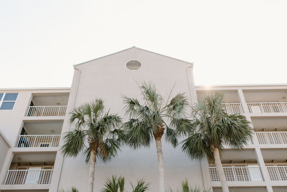 Edificio de apartamentos con balcones y palmeras en primer plano