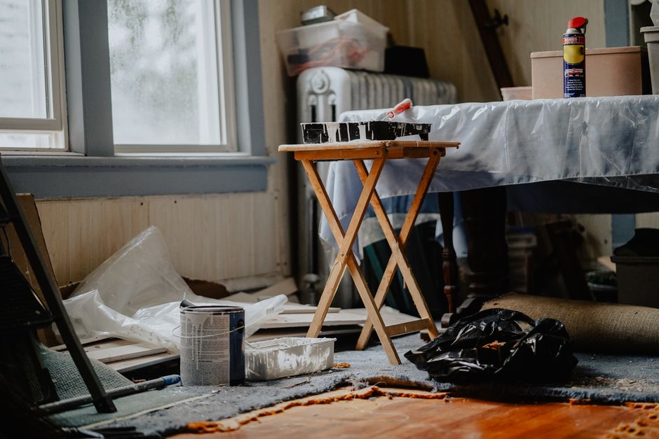 Habitación de una vivienda en plena reforma con botes de pintura y material de obra en el suelo