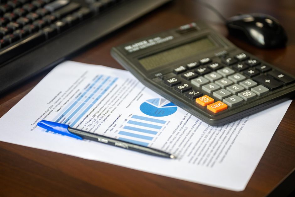 Calculadora e informe con cifras sobre la mesa de un despacho, para calcular el salario regulador de una indemnización